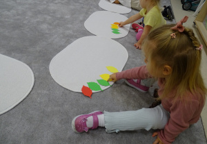 dzieci układają rytmy z kasztanów i liści