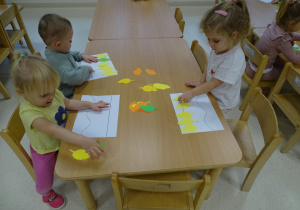 dzieci układają rytmy z kasztanów i liści