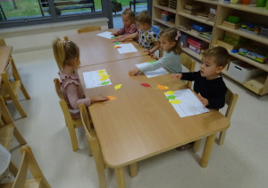 dzieci układają rytmy z kasztanów i liści