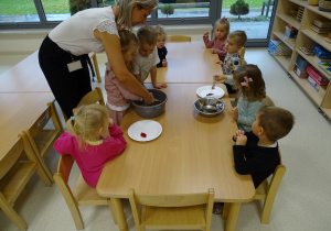 dzieci wyciągają liście z wody spinaczami