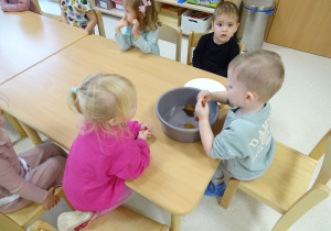 dzieci wyciągają liście z wody spinaczami