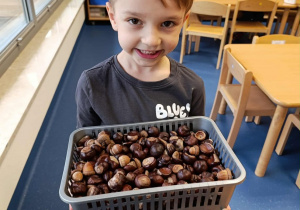 chłopiec trzyma kasztany