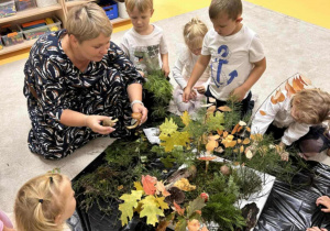 Nauczyciel tłumaczy dzieciom, jakie drzewa rosną w lesie