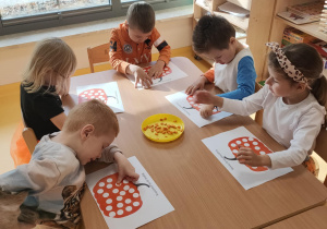 praca plastyczna przy stolikach- wyklejanie dyni