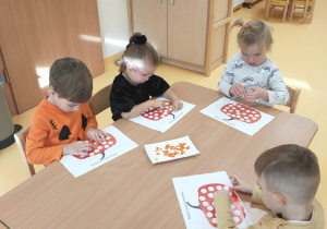 Dzieci wyklejają dynię