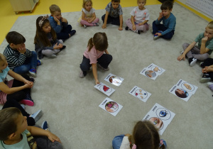 Dziewczynka kładzie obrazek na dywanie