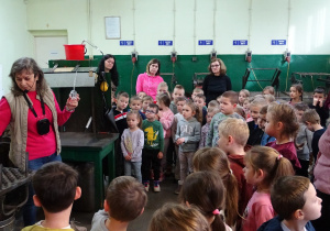 Pani opowiada dzieciom o procesie powstawania bombek