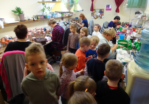 Dzieci oglądają ręczny proces ozdabiania szklanych bombek