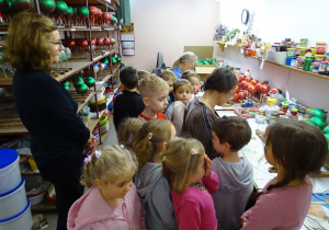 Dzieci oglądają ręczny proces ozdabiania szklanych bombek