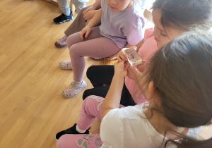 Dzieci przekazują sobie z rąk do rąk mrówkę