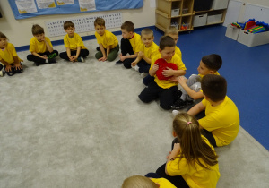 Dzieci podają sobie czerwone serduszko i miłe słowo