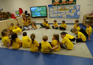 Dzieci siedzą w kole i rozmawiają o życzliwości