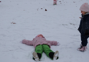 dziewczynka robi aniołka na śniegu