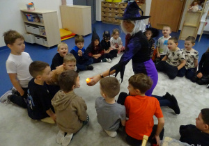 Czarodziejka pokazuje dzieciom czary ze znikającym płomieniem