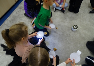 Dzieci podświetlają latarką swoje eliksiry