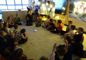 Dzieci siedzą w kole wokół magicznej kuli