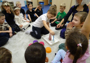 Dzieci nalewają pipetą składnik eliksiru do flakonika