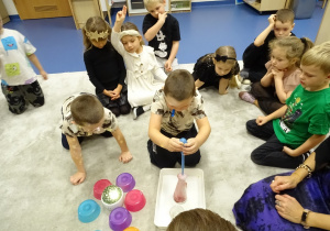 Dzieci nalewają pipetą składnik eliksiru do flakonika