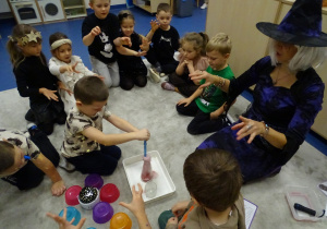 Dzieci nalewają pipetą składnik eliksiru do flakonika