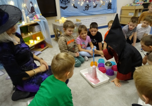 Dzieci nalewają pipetą składnik eliksiru do flakonika