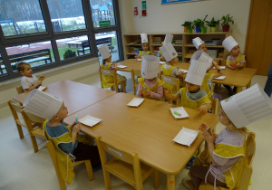 dzieci siedzą przy stolikach