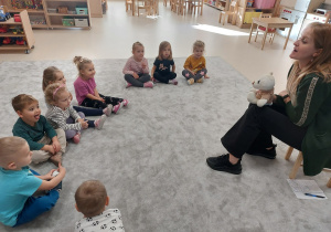 Dzieci w półkolu obserwują logopedę