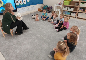 Dzieci pokazują misiowi Lulusiowi nadmuchane w balonik policzki