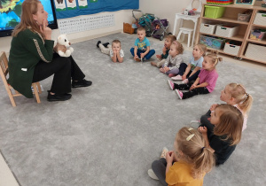 Logopeda wskazuje palcem policzek, a dzieci dotykają językiem policzek od wewnętrznej strony