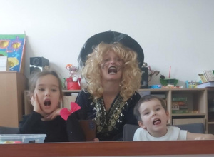 Dziewczynka, logopeda i chłopiec unoszą język do dziąseł górnych