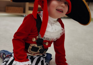 Chłopiec -pirat oblizuje zęby od wewnętrznej strony