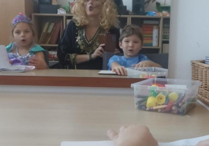 Dzieci z panią logopedą ćwiczą wargi przed lustrem