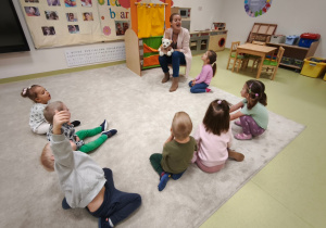 Logopeda prezentuje przed dziećmi ćwiczenie języka.