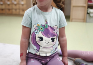 Dziewczynka liczy językiem zęby górne- wskazuje miejsca na widowni.