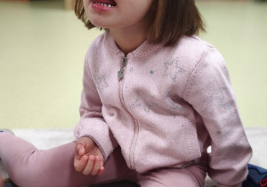 Dziewczynka oblizuje wargę górną.