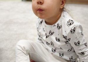 Dziewczynka ma napompowane policzki.