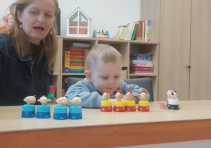 Logopeda prezentuje samogłoski, chłopiec powtarza tyle razy, ile ustawił zwierzątek