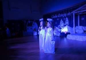 Dziewczynki aniołki witają gości i zapraszają do oglądania przedstawienia