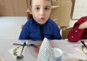 Chłopiec przy wigilijnym stole.