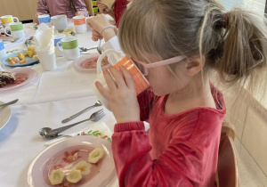 Dzieci jedzą wigilijne potrawy.