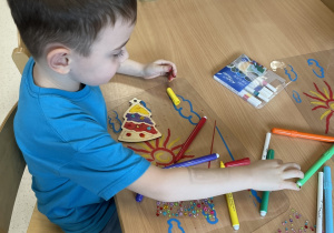 Miłosz ozdabia choinkę.