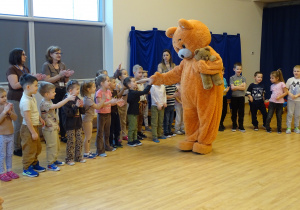 Miś wita się z dziećmi.