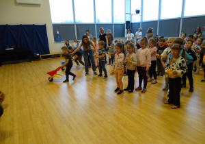 Dzieci wożą misie na taczkach.