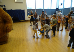 Dzieci wożą misie na taczkach.