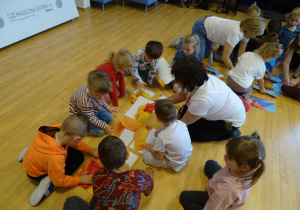 Dzieci składają obrazek z części.