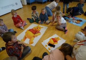 Dzieci z obrazkiem Kubusia Puchatka.