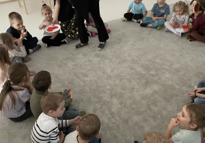 Wróżka rozdaje dzieciom serduszka z imionami.