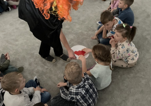 Wróżka rozdaje dzieciom serduszka z imionami.