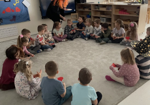 Wróżka rozdaje dzieciom serduszka z imionami.