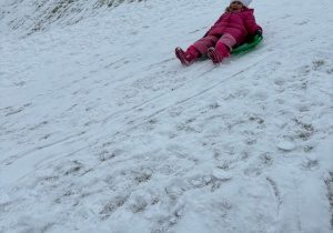 Dziewczynka zjeżdża z górki