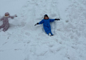 Chłopiec robi aniołka na śniegu